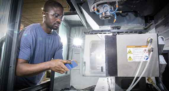 machine operator places solid plastic in cnc machine