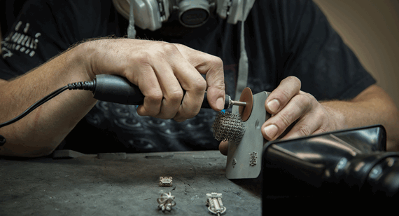 a 3D printing technician removes metal supports on a DMLS part