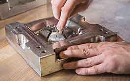 engineer removing molded part from injection molding block